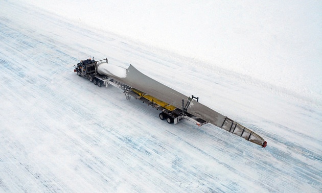 A truck hauling one of the 33-metre-long turbine on an ice covered road. 