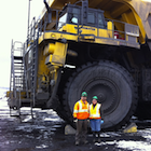 Roland and Elsie Antuna stand in front of a haul truck at Peace River Coal