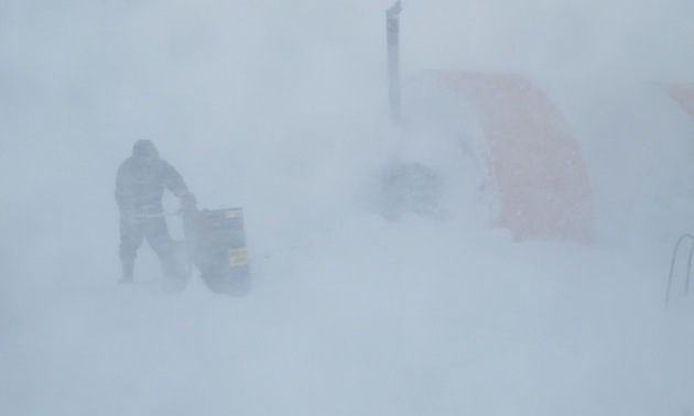 April 4, 2013, was the first day of a four-day whiteout. Here, Daniel Akpalialuk, a worker from Pangnirtung, Nunavut, is shown fuelling one of the tents to keep the camp running. 