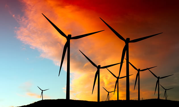 Picture of wind farm towers with beautiful sunset in background. 